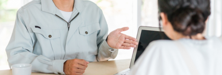 職人がお客様に雨漏りや塗装の施工を案内をしている様子